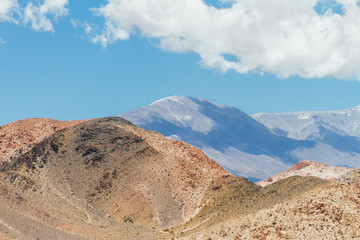 Orange hill with peaks behind in Catamarca, Argentina