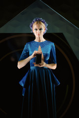 Fototapeta premium Beautiful fashion model holding smartphone in her hands. Presentation.