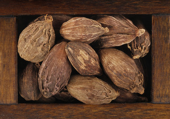 black cardamom in wooden box isolated