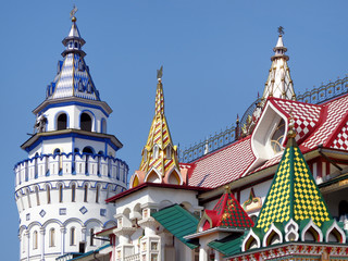 Fototapeta na wymiar Multicolored towers and domes on a background of the blue sky