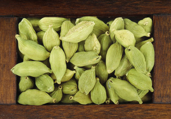 green cardamom in wooden box isolated