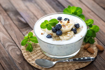 Yogurt with fresh blueberry, banana and almond nuts, delicious dessert for healthy breakfast