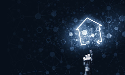 Conceptual image with hand pointing at house or main page icon o