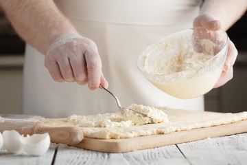 chef cooking (preparing cottage cheese pancakes) on a wooden board