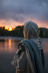 Jesus Christ looking over a lake during a sunset