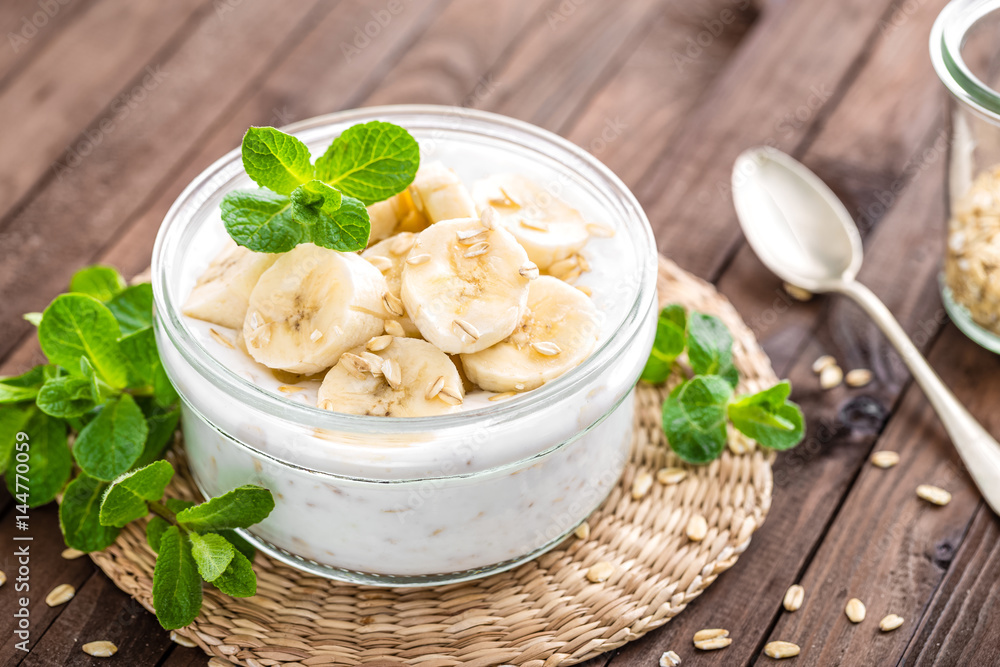 Poster fresh banana yogurt with oats, delicious dessert for healthy breakfast