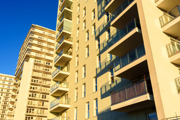 Obraz premium Modern apartment block with balcony against a blue sky.
