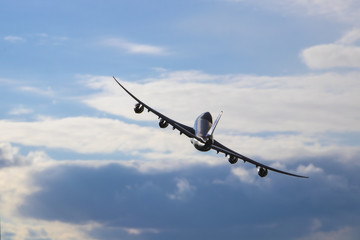 Airplane flying in the cloudy sky. Turn right.