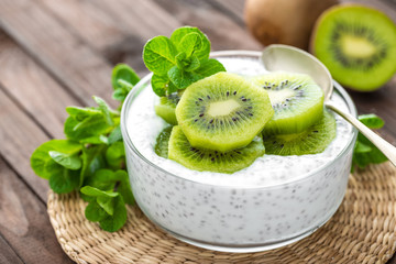 Fototapeta na wymiar Fresh kiwi yogurt with fruits and chia seeds, healthy breakfast