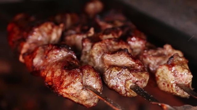 Cooking shashlik on skewers. Pork meat grilled on charcoal grill. Asian cuisine