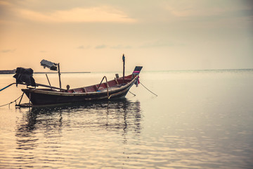 Fototapeta na wymiar Tranquil sea scenery with traditional floating asian boat during sunset