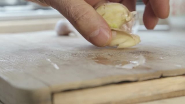 Crashing garlic cloves with chef knife