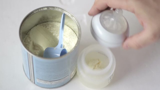 Man makes infant milk formula for a baby