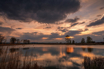 Naklejka na ściany i meble Sunset over calm lake , sky reflection in water