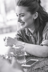 Beautiful, loving guy and girl are sitting in a cafe, talking, laughing. A girl laughs with his stories. Love story