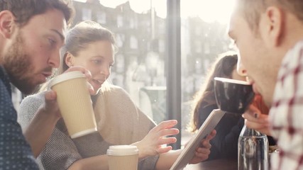  Happy group of friends chatting & using technology in city coffee shop - Powered by Adobe