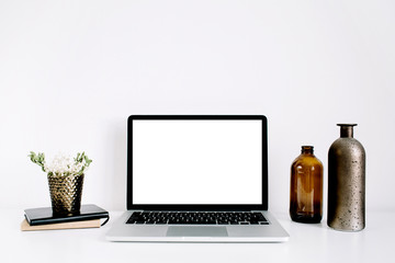 Blogger or freelancer workspace with front view of laptop with blank screen at white background. Minimalistic decorated home office desk.