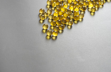 Fish oil supplement capsules source of omega 3 on dark background.