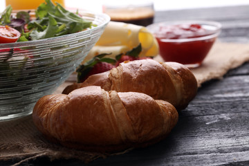 breakfast on table with salad, croissants, coffe and juice