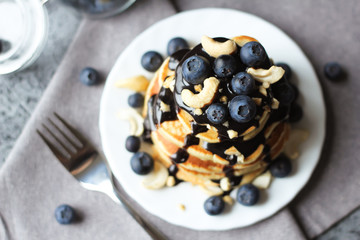 Stack of pancakes with blueberries and chocolate sauce. Top view.