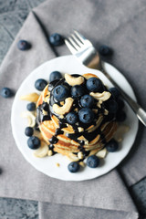 Stack of pancakes with blueberries and chocolate sauce. Top view.
