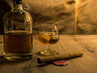 Whisky Flasche, Whisky Glas mit Eiswürfeln und eine Zigarre - obrazy, fototapety, plakaty