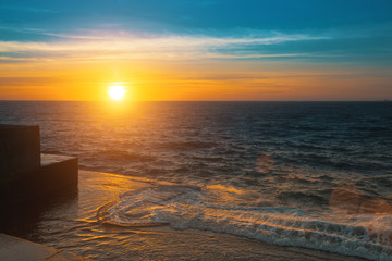 Stunning sunset on the sea a stone embankment.