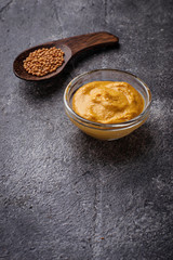Mustard and seeds on concrete background