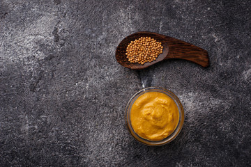 Mustard and seeds on concrete background
