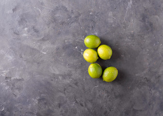 Lime on a gray background. Citrus fruits on gray abstract background. Mixed festive colorful tropical and citrus fruit. Healthy eating photo concept. Copyspace