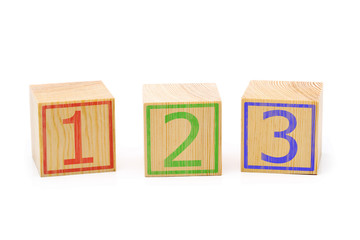 Three brown wooden cubes lined up in a row with numbers one, two and three - education or counting...