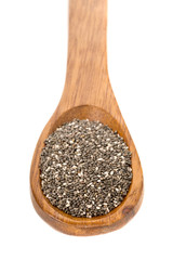 Whole dried black chai seeds in wooden spoon