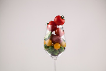 Vertical shot on wineglass with small fresh vegetables in it.
