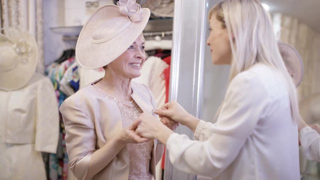 Bride to be shopping for an outfit with her mother in bridal wear store.