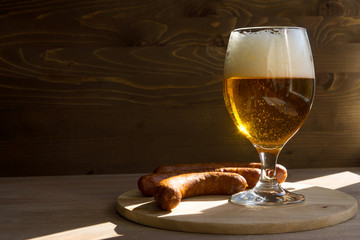 beer mug on a wooden table with sausage