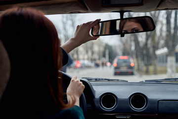 A woman is driving a car Looks in the mirror