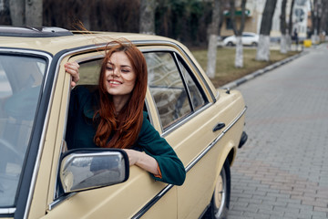 red-haired woman peeking out of car window