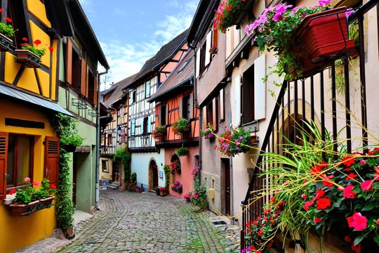 Quaint colorful cobblestone lane in the Alsatian town of Eguisheim, France