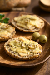 Baked ham, green olive and cheese sandwich with oregano, photographed with natural light (Selective Focus, Focus on the front of the olive slices on first sandwich)