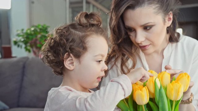 Mother and daughter holding yellow tulips