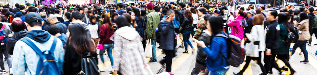 crowd of people in motion blur crossing a street