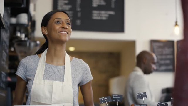  Cheerful Worker Serving A Customer Who Uses Smartphone To Pay In Coffee Shop.