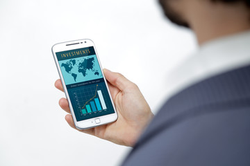Business Man´s smartphone with a investment web page on the screen. Investment graphics, bar graphics, world investments, marketing, ecommerce, web page through a cell phone, responsive web design.