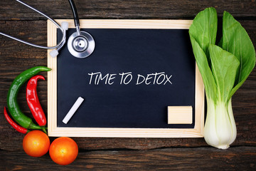 Nutrition food, stethoscope and blackboard written with TIME TO DETOX on wooden background.