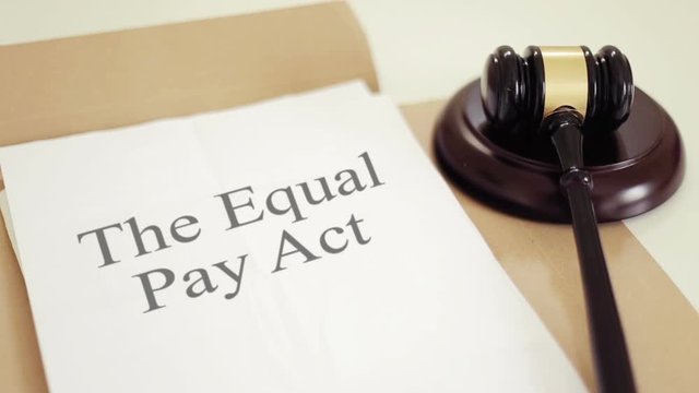The Equal Pay Act written on folder with gavel placed on desk of judge in court
