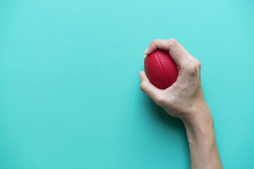 hand holding stress ball on green background