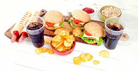 fast food and cola drink on wooden board. Unhealthy eating concept