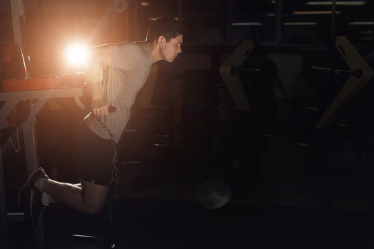 Muscular bodybuilder working out in gym doing exercises parallel bars. Concept sport. copy space.
