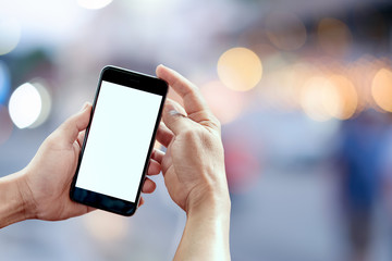 Smart phone showing blank screen in man hand at walk street,night light bokeh Background