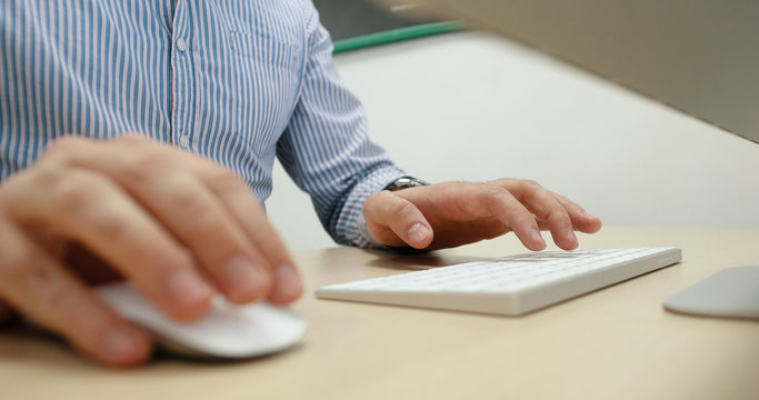 hands typing on computer keyboard in startup office